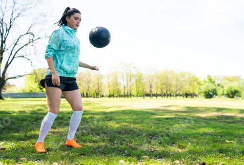 Preview: Young woman practicing soccer skills with ball.