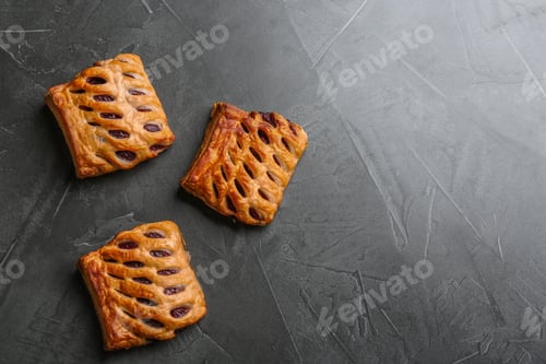 Preview: Fresh delicious puff pastry on grey table, top view. Space for text
