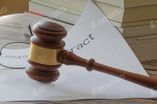 Preview: Mallet on a legal document with books and reading glasses