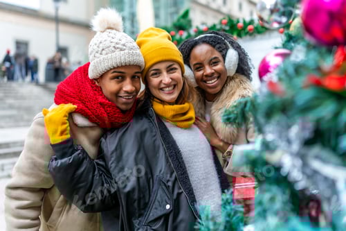 Preview: Happy multi ethnic friends enjoying christmas city during winter holidays