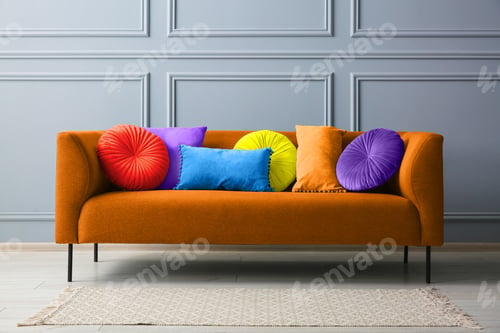 Preview: Stylish orange sofa with cushions near grey wall