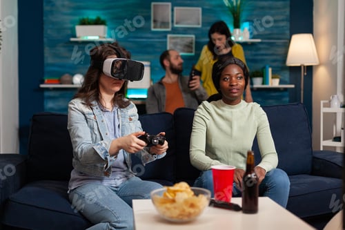 Preview: Excited woman playing video games wearing vr headset