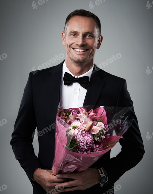 Preview: Hes an old-fashioned suitor. Portrait of a well-dressed man holding a bouquet of flowers.