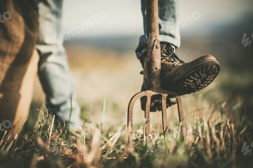 Preview: Cowboy Rancher Resting His Leg on a Garden Fork