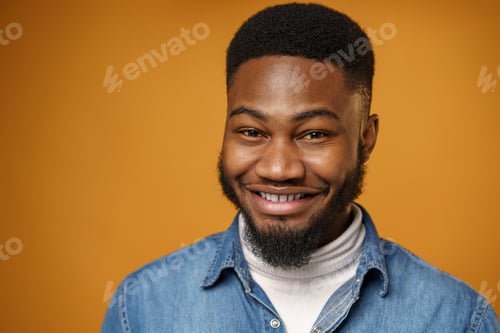 Preview: Portrait of young handsome african american guy against yellow background