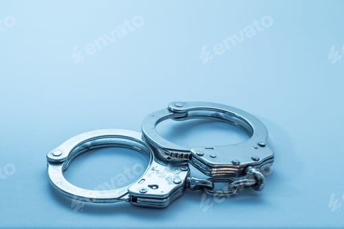Preview: Close up shot of handcuffs isolated on a blue background