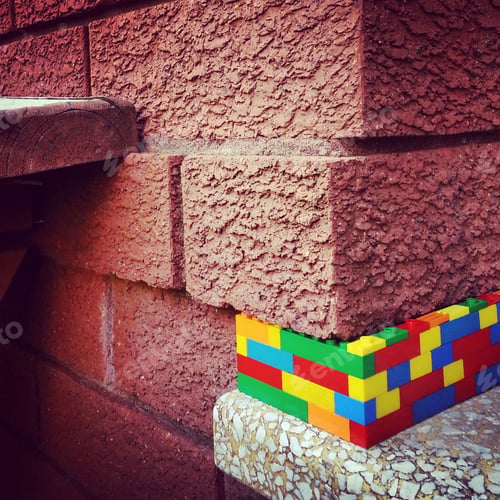 Preview: Street art,colourful plastic blocks in brick wall