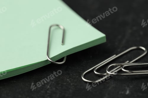 Preview: Paper notes and clips on black table, closeup