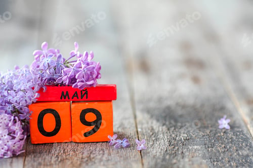 Preview: Wooden calendar with Russian text May 9 and a bouquet of lilacs . Victory Day. Copy space.