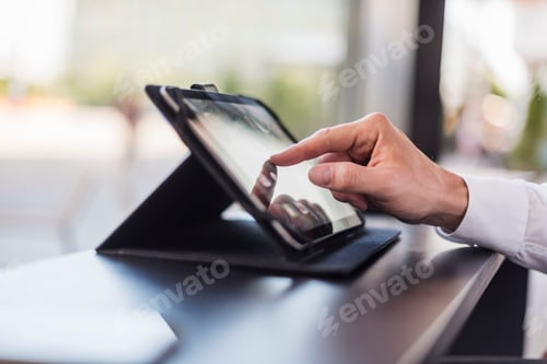 Preview: Close-up of businessman using tablet in a cafe