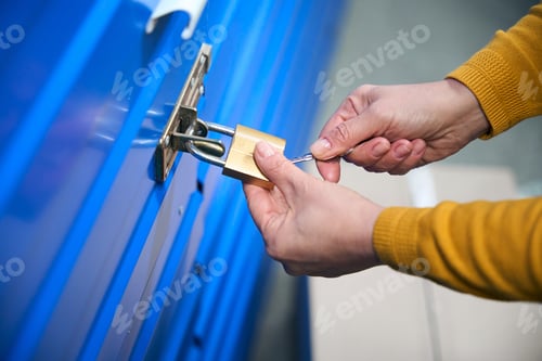 Preview: Lady in a sweater opens a padlock with her keys