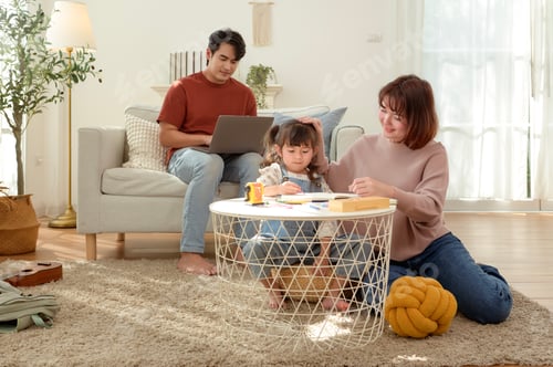 Preview: Girl Works on Homework With Parents Nearby in Living Room During Afternoon