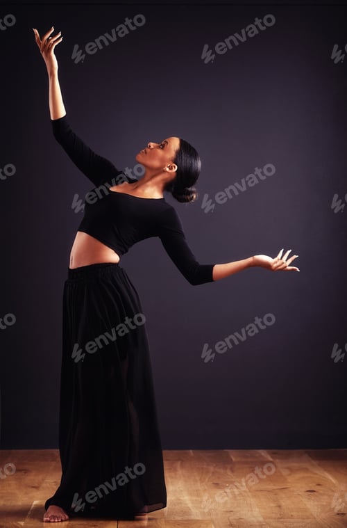 Preview: A feel for the theatrical. Female contemporary dancer in a dramatic pose against dark background.