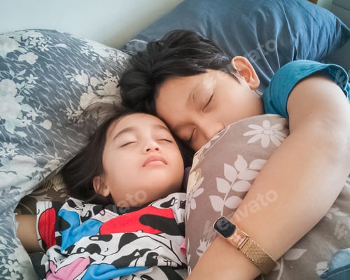 Preview: Siblings sleeping on the bed.