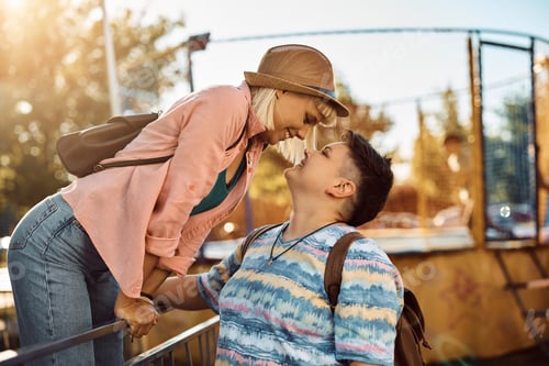Preview: Young lesbian couple about to kiss while spending day at amusement park.