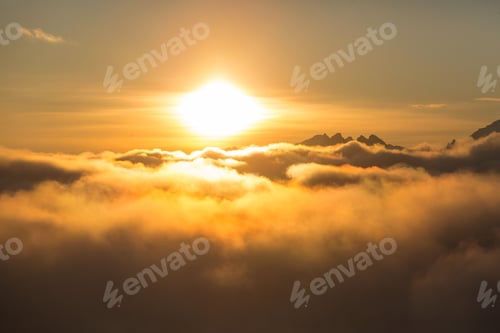 Preview: Golden Sunlight Above Clouds Over Mountain Peaks