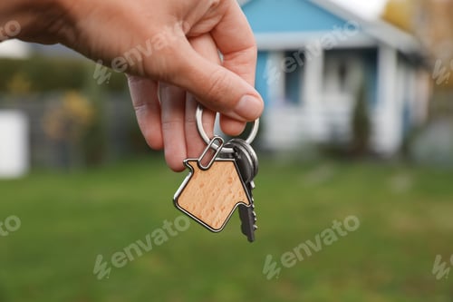 Preview: Woman holding house keys outdoors, closeup. Real estate agent
