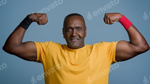 Preview: Portrait mature sports african man posing in studio gray background strong muscular athletic male