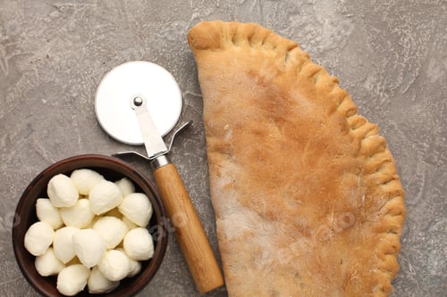 Preview: Pizza calzone with basil leaves close up with restaurant background. classic italian food