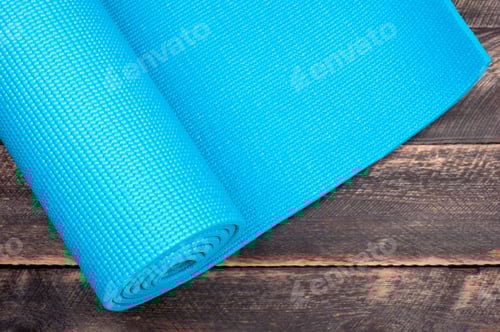 Preview: Yoga mat on a wooden background. Equipment for yoga. Concept healthy lifestyle