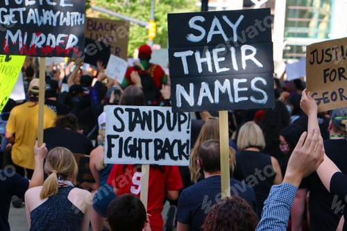 Preview: Say Their Names: Image of protesters from behind holding signs at a Black Lives Matter rally.