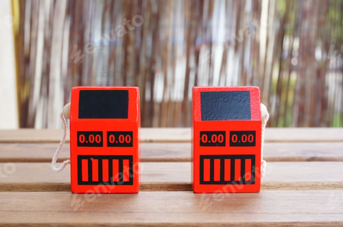 Preview: Selective focus shot of red miniature gas stations on a wooden table