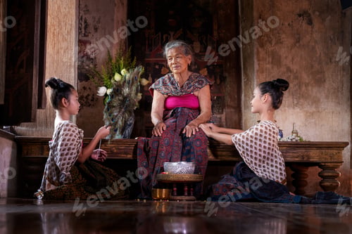 Preview: Asia family pour water on the hands of revered elders, grand parent doing for respected and ask for