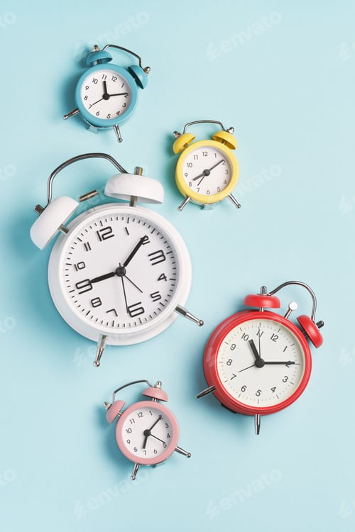 Preview: Collection of alarm clocks of different colors show different times.