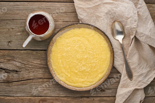Preview: porridge polenta with cup tea, dark wood background, top view
