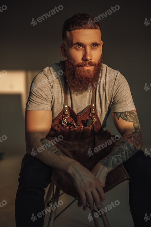Preview: Serious barber sitting on stool