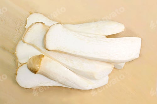 Preview: Slices of white King Oyster Mushroom stems on chopping board