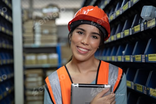 Preview: woman wearing visible vest hold clipboard in warehouse check and arrange box in the steel shelf