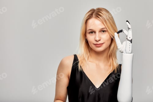 Preview: Studio portrait of beautiful young blonde girl with disability wearing sensory bionic prosthetic arm