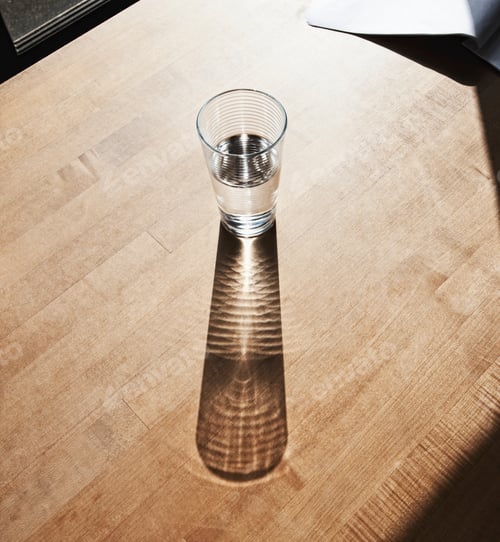 Preview: Glass of drinking water on wooden surface.