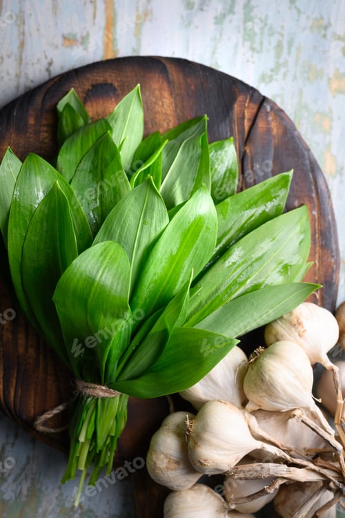 Preview: Fresh wild garlic leaves arranged on rustic wooden cutting board