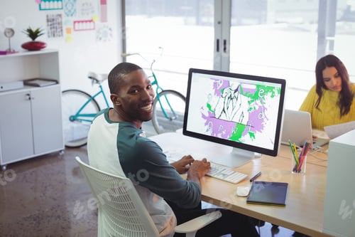 Preview: Smiling male designer working in creative office