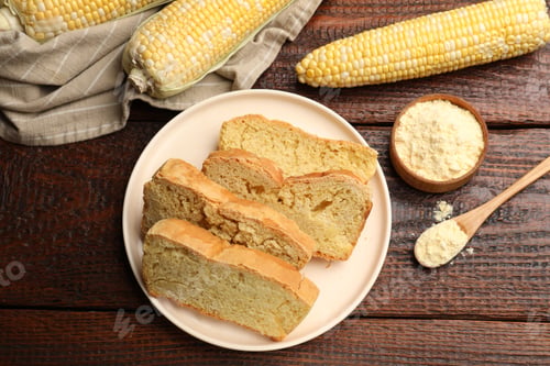 Preview: Freshly baked cornbread, cobs and flour on wooden table, flat lay
