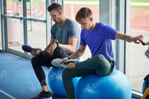 Preview: Two Young Men Stretching on Exercise Balls