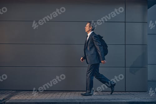 Preview: Handsome man with backpack walking on the street