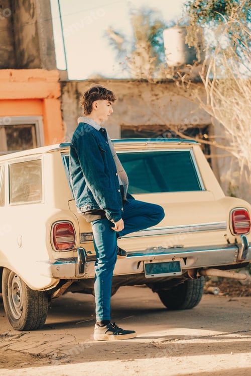 Preview: Caucasian male standing near retro car