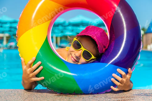 Preview: The child swims in the pool in a circle. Selective focus.