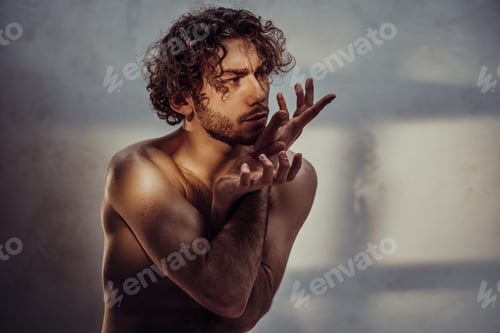 Preview: Young caucasian male model is naked and isolated on the grey background