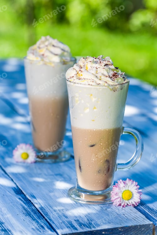 Preview: Cold coffee in sunny garden on old wooden table
