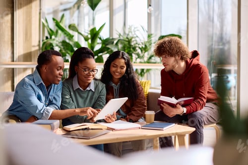 Preview: Happy diverse students using digital tablet while studying together at the university.