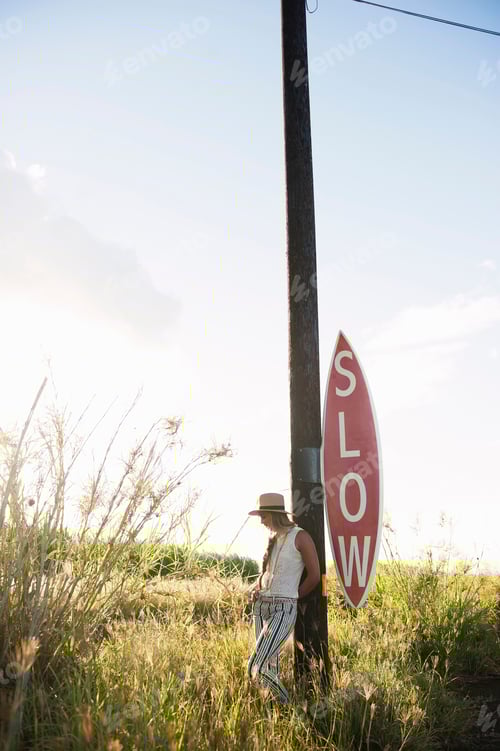 Preview: Contemplative moment by a rural slow sign.