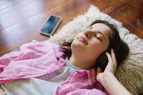 Preview: Teengirl Relaxing on the Floor With Headphones and a Drink