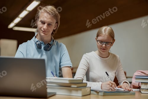 Preview: Students sit in the library and take notes while preparing for the exam