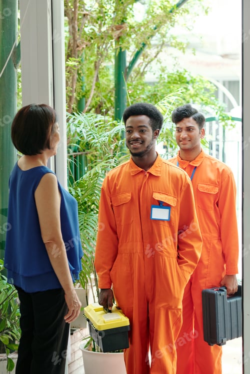 Preview: Mature woman smiling to repair workers