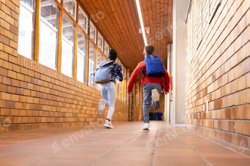 Preview: Running down school hallway, multiracial boy and girl with backpacks heading to classroom