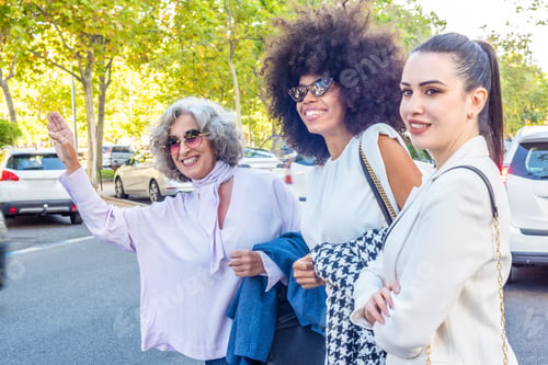 Preview: three businesswomen waiting for a taxi after a working day